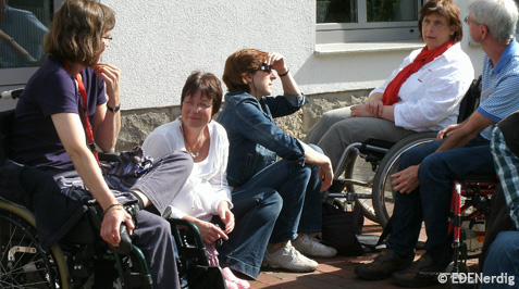 Gruppe Menschen mit und ohne Handicap im Gespraech